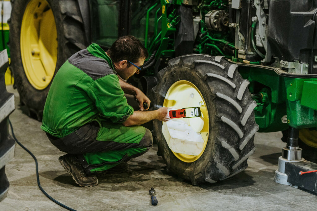 Un ouvrier qui répare du matériel agricole John Deere